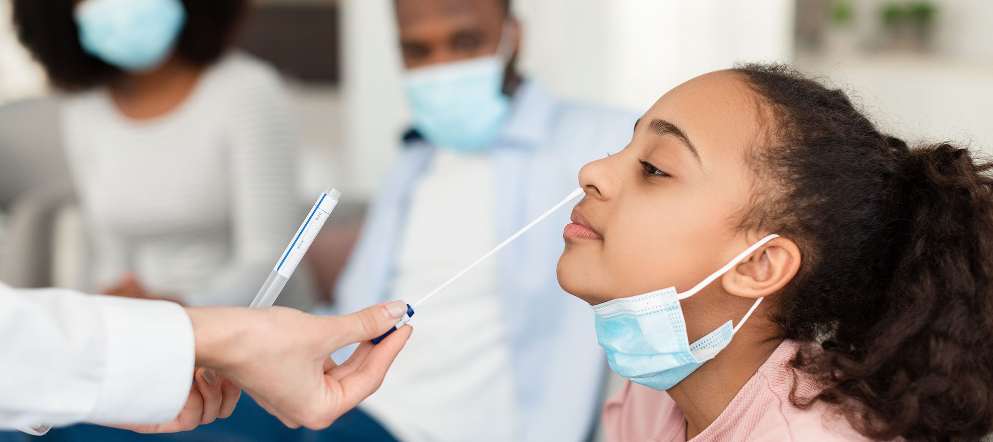 Young black child getting a nose swab COVID-19 test