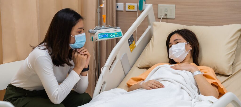 woman visiting and take care female patient on bed at hospital.