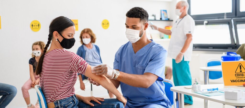 Woman with face mask getting vaccinated