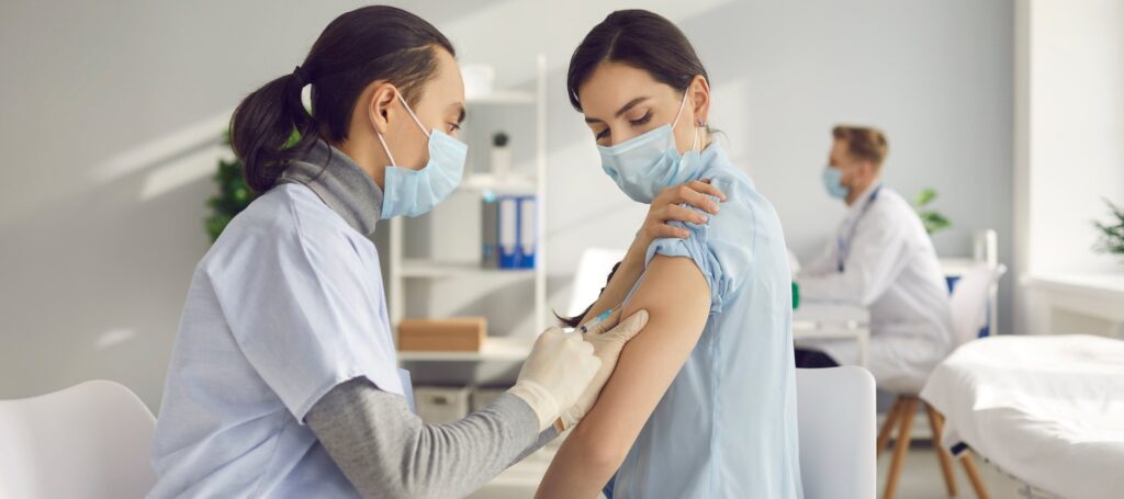 Young woman gets vaccinated at clinic or health center.