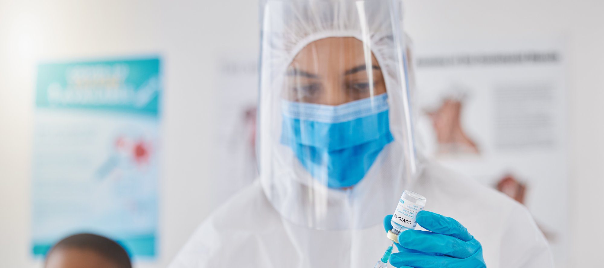 Frontline worker in hazmat suit getting ready to inject patient