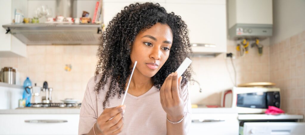 black woman doing self covid-19 test at home