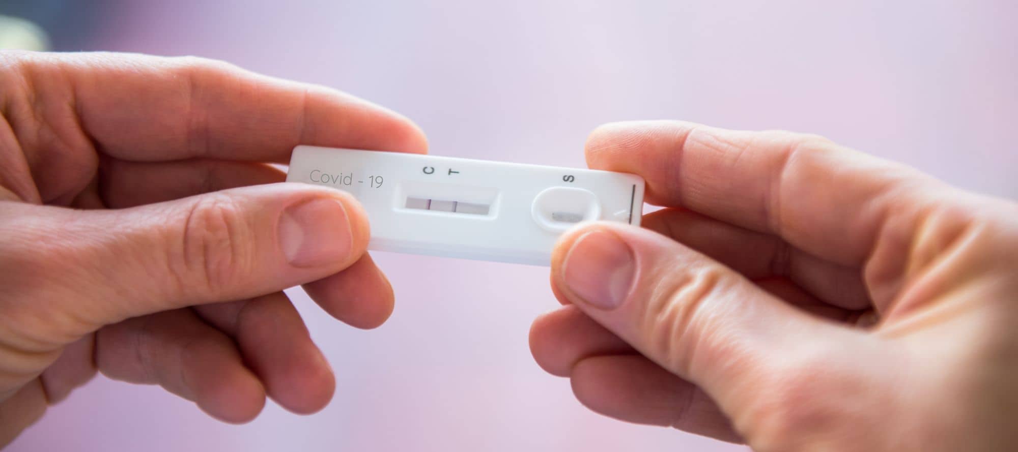 Hands holding rapid covid -19 test with a positive result